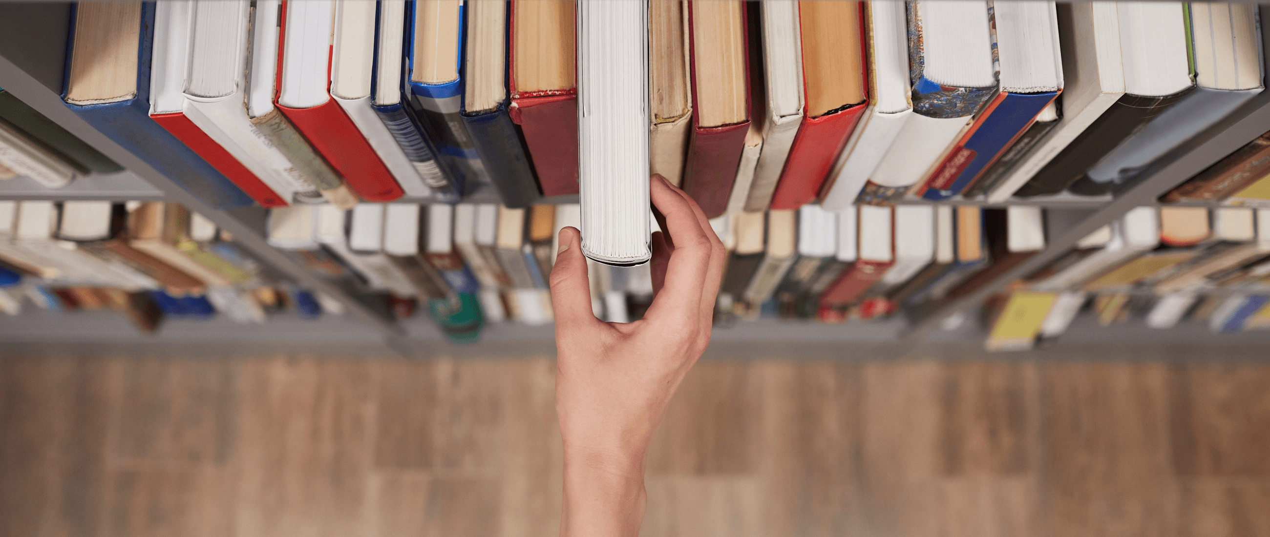 Fotografía de una mano cogiendo un libro