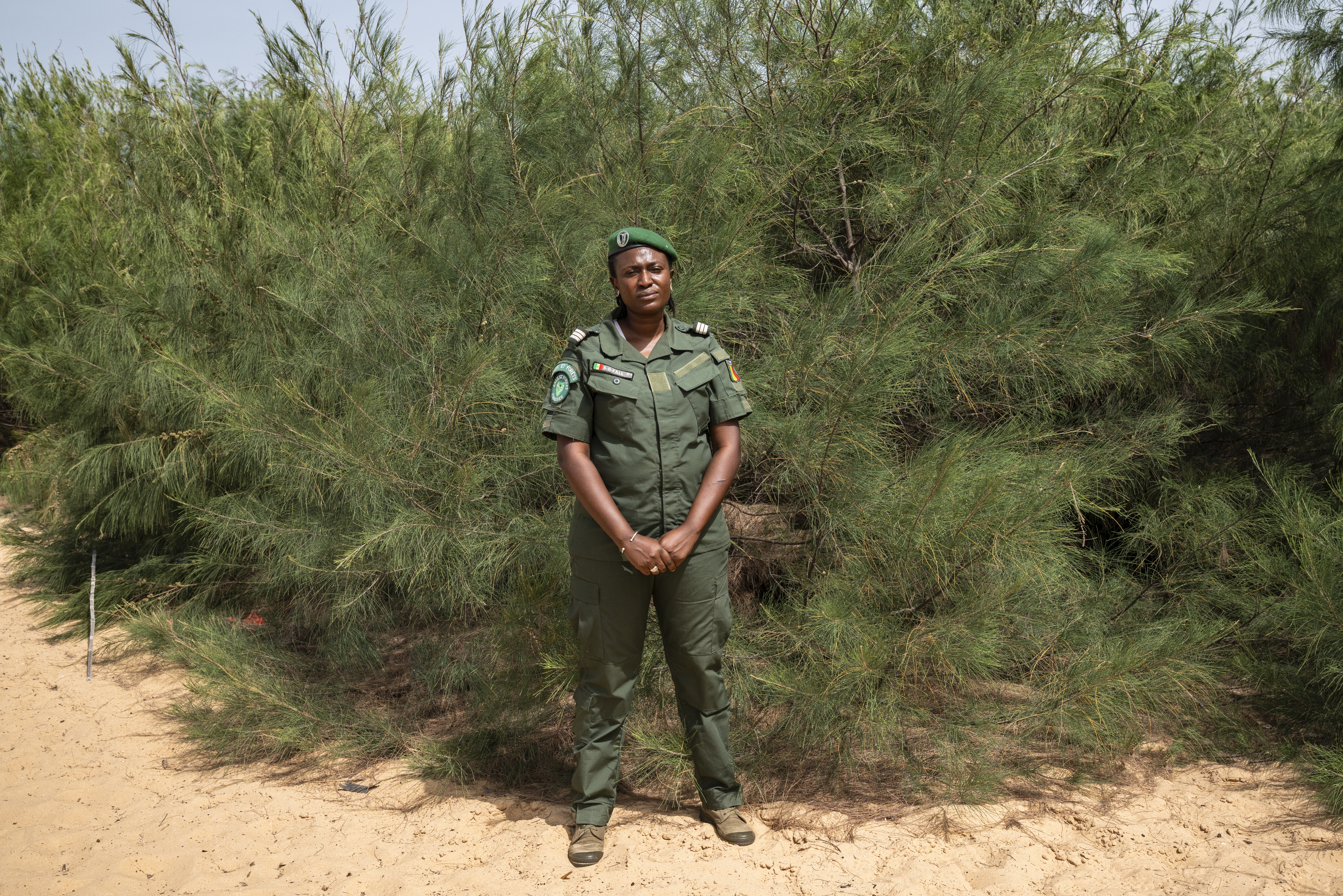 La capitana y agente forestal Seynabou Fall posa delante de un bosque de filaos. Foto: AECID/Marta Moreiras